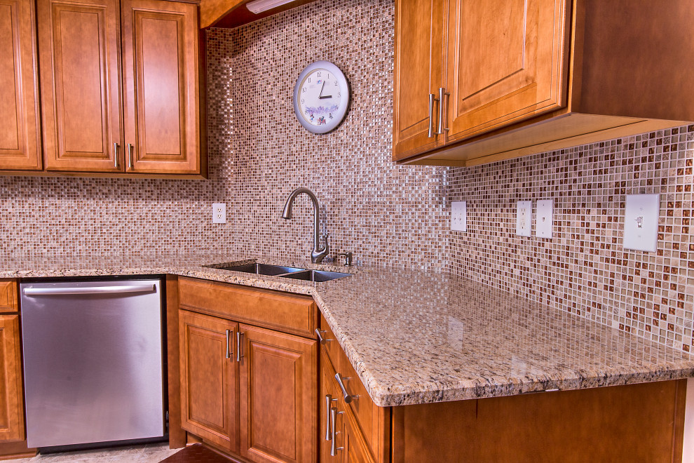 Eat-in kitchen - mid-sized l-shaped cement tile floor eat-in kitchen idea with an undermount sink, raised-panel cabinets, medium tone wood cabinets, granite countertops, brown backsplash, mosaic tile backsplash, stainless steel appliances, an island and brown countertops