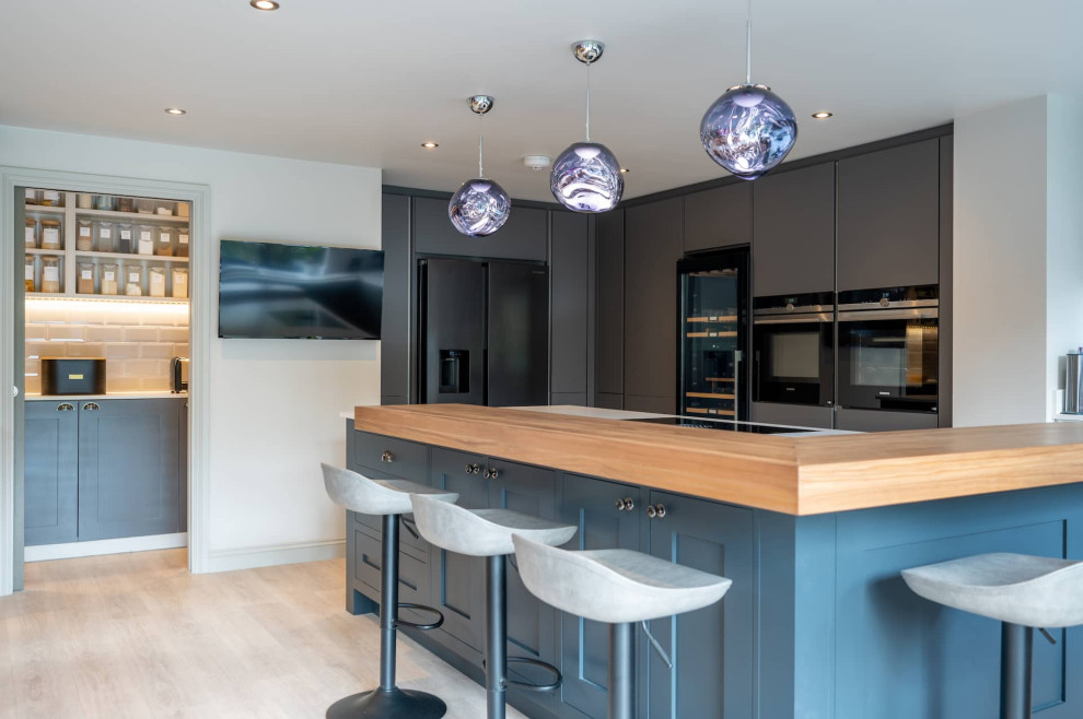 Große Moderne Wohnküche in L-Form mit flächenbündigen Schrankfronten, grauen Schränken, Quarzit-Arbeitsplatte, Küchenrückwand in Weiß, Kücheninsel und weißer Arbeitsplatte in Hertfordshire