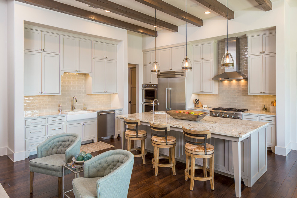 Example of a transitional medium tone wood floor open concept kitchen design in Austin with a farmhouse sink, shaker cabinets, gray cabinets, gray backsplash, stainless steel appliances and an island