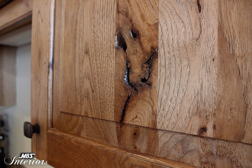 Inspiration for a rustic l-shaped kitchen remodel in Columbus with recessed-panel cabinets, medium tone wood cabinets, laminate countertops and black appliances
