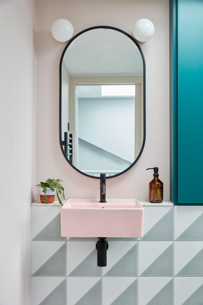 Идея дизайна: маленькая ванная комната: освещение в скандинавском стиле с плоскими фасадами, синими фасадами, инсталляцией, разноцветной плиткой, керамической плиткой, розовыми стенами, полом из керамической плитки, подвесной раковиной, столешницей терраццо, разноцветным полом, разноцветной столешницей и встроенной тумбой для на участке и в саду