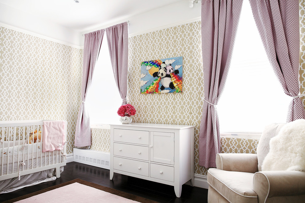 Photo of a transitional nursery for girls in New York with beige walls and dark hardwood floors.