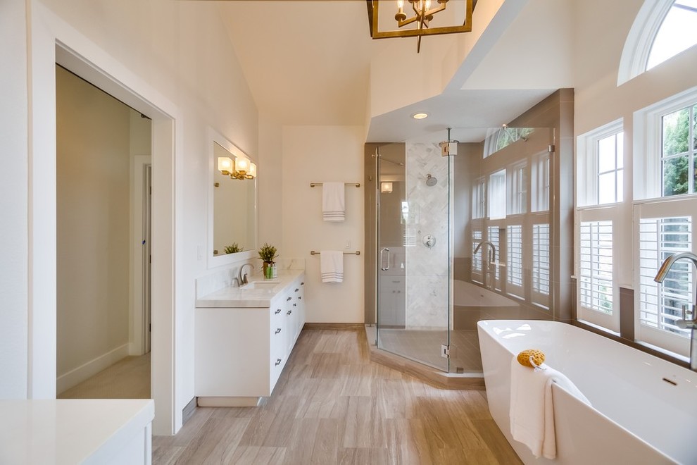 Large transitional master bathroom in San Diego with flat-panel cabinets, white cabinets, a freestanding tub, a corner shower, a two-piece toilet, grey walls, ceramic floors, an undermount sink and marble benchtops.