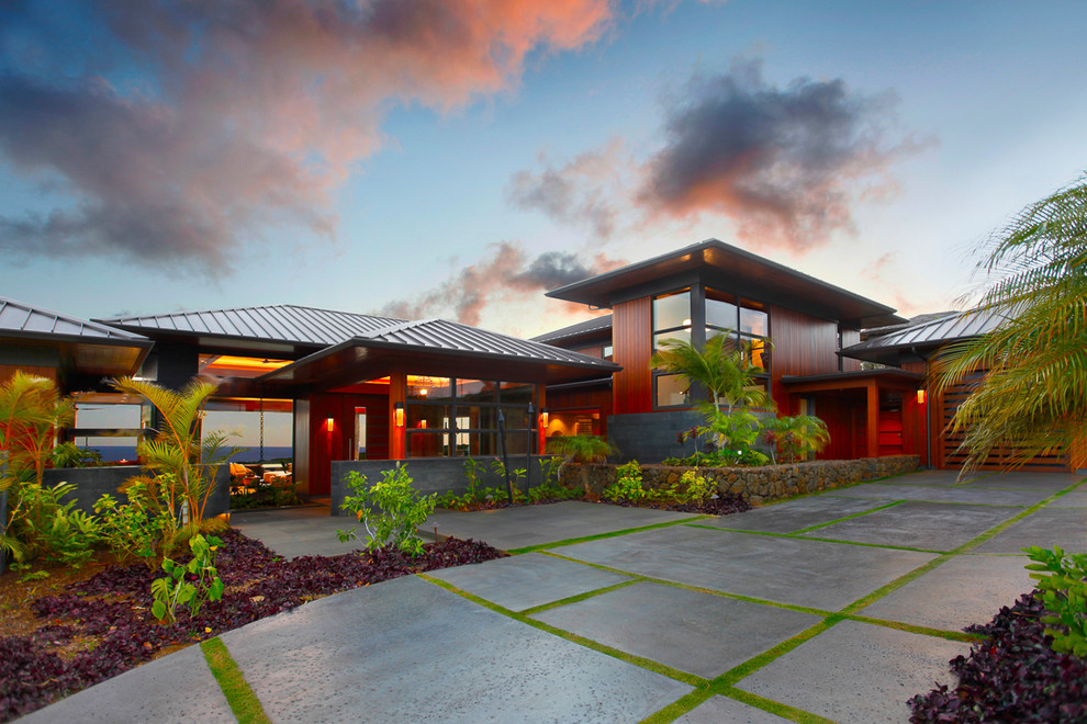 Inspiration for an expansive tropical two-storey brown house exterior in Hawaii with wood siding, a hip roof and a metal roof.