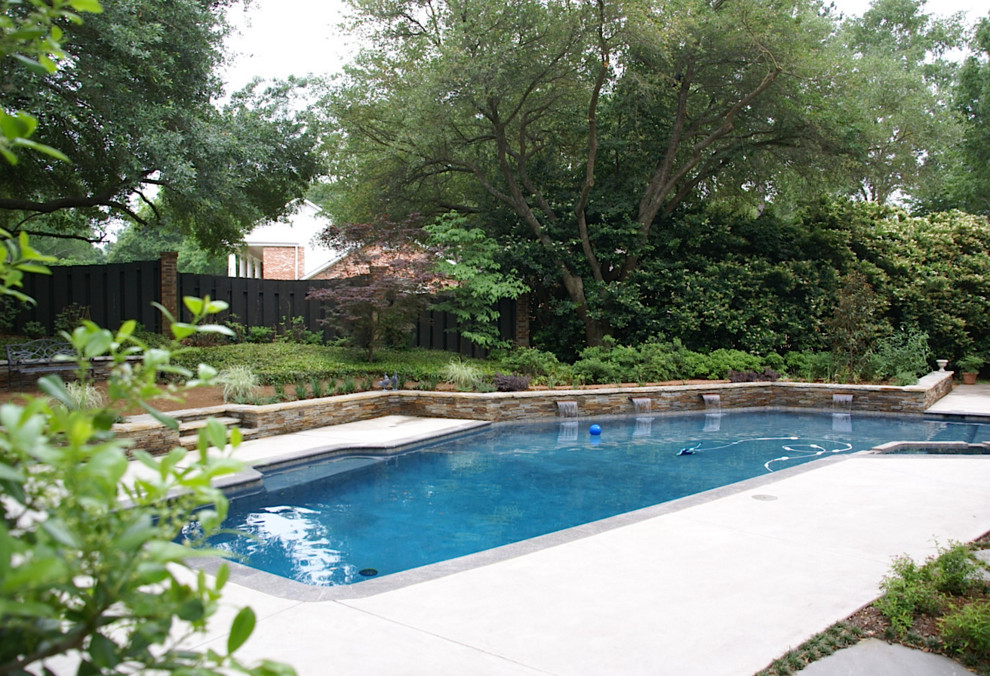 Photo of a large contemporary backyard custom-shaped pool in Houston with a hot tub and concrete slab.