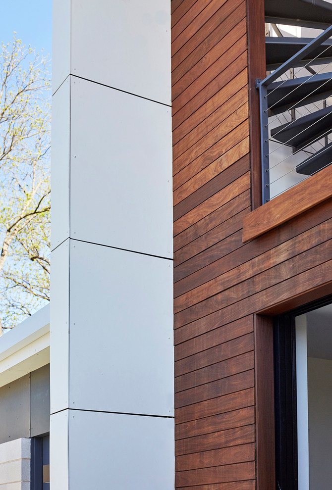 Photo of a mid-sized modern two-storey house exterior in Dallas with concrete fiberboard siding and a flat roof.