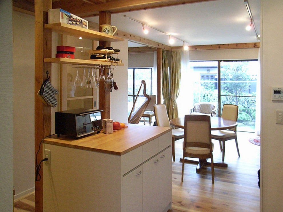 Mid-sized scandinavian single-wall open plan kitchen in Tokyo Suburbs with flat-panel cabinets, cork floors, with island and beige floor.