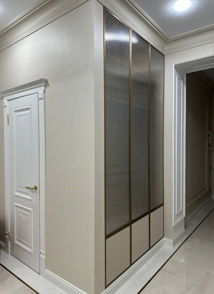 Шкаф в прихожую, интегрированный в стену, с алюминиевыми вставками и рифлением.