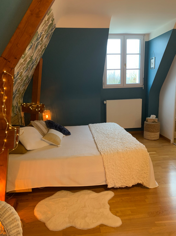 На фото: спальня среднего размера на антресоли в морском стиле с синими стенами, светлым паркетным полом, коричневым полом, балками на потолке и обоями на стенах без камина с