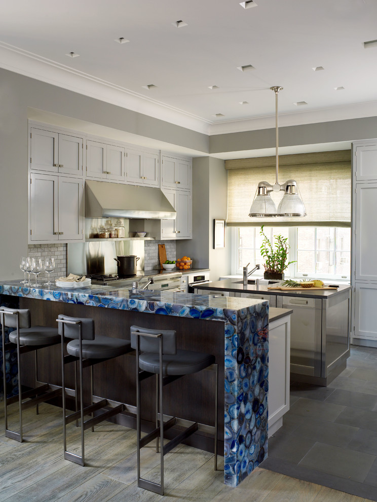 Photo of a transitional kitchen in New York with shaker cabinets, grey cabinets, grey splashback, stone tile splashback, stainless steel appliances, slate floors and with island.