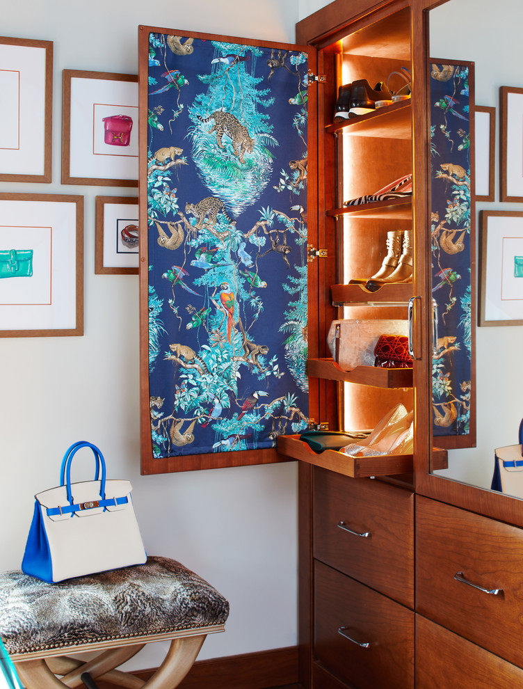 Photo of a mid-sized transitional women's storage and wardrobe in New York with medium wood cabinets.