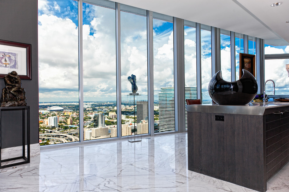 Example of a mid-sized transitional single-wall marble floor eat-in kitchen design in Miami with an undermount sink, flat-panel cabinets, black cabinets, marble countertops, gray backsplash, stone tile backsplash and an island