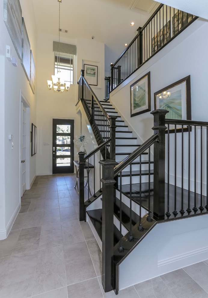 Large transitional wood l-shaped staircase in Houston with painted wood risers.