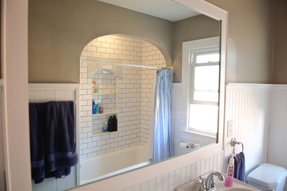 Small midcentury bathroom in Indianapolis with flat-panel cabinets, white cabinets, a drop-in tub, a shower/bathtub combo, white tile, ceramic tile and marble floors.