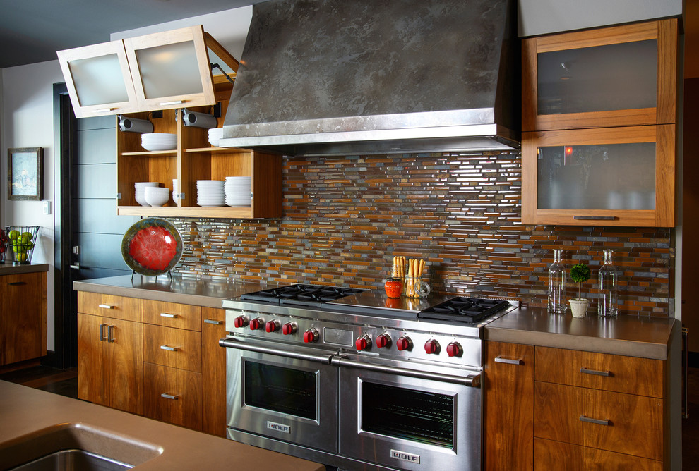 Inspiration for a transitional eat-in kitchen remodel with an undermount sink, flat-panel cabinets, medium tone wood cabinets, concrete countertops, multicolored backsplash, glass tile backsplash and stainless steel appliances
