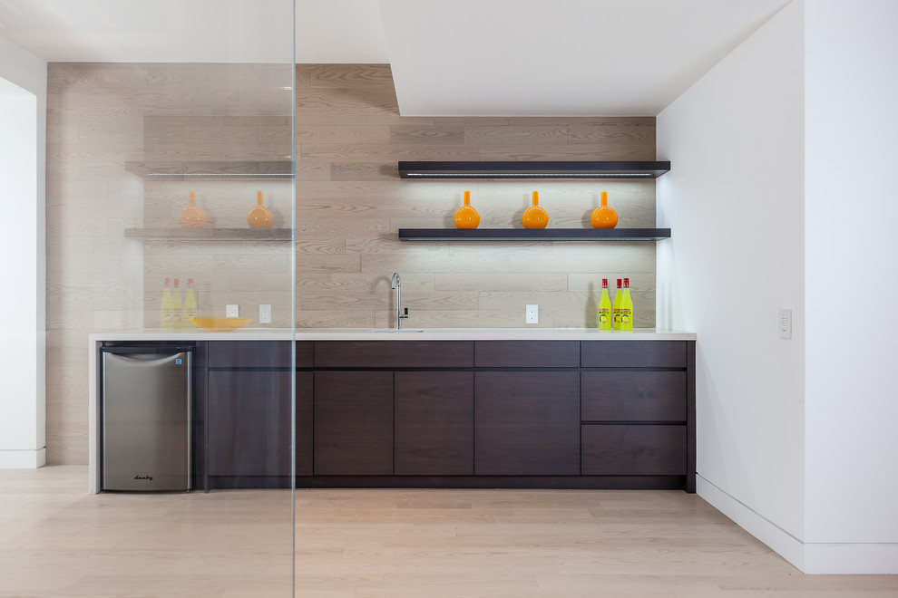 Photo of a large contemporary single-wall wet bar in Toronto with an undermount sink, flat-panel cabinets, dark wood cabinets, brown splashback, timber splashback, light hardwood floors and brown floor.