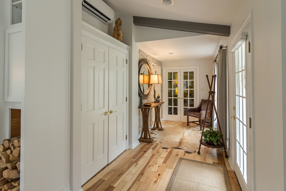 Entry hall - mid-sized transitional medium tone wood floor entry hall idea with white walls and a glass front door