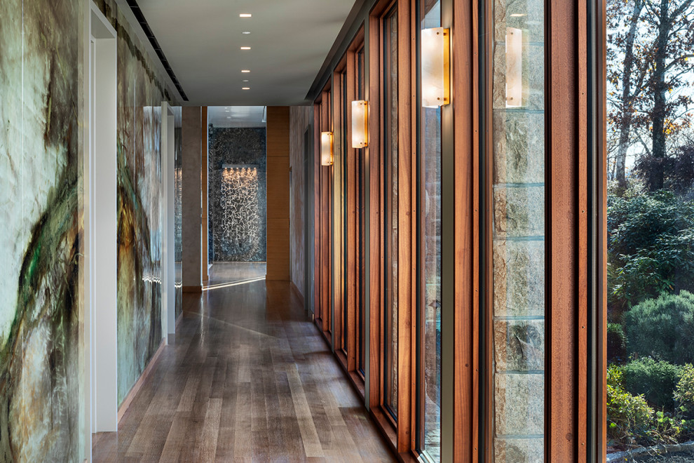 Geräumiger Moderner Flur mit grüner Wandfarbe, braunem Holzboden, beigem Boden und Wandpaneelen in New York