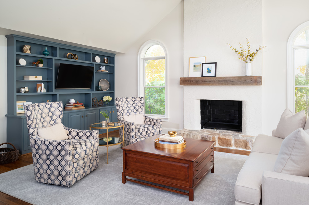 Inspiration for a transitional family room in Philadelphia with a standard fireplace, a plaster fireplace surround, white walls, medium hardwood floors and a built-in media wall.