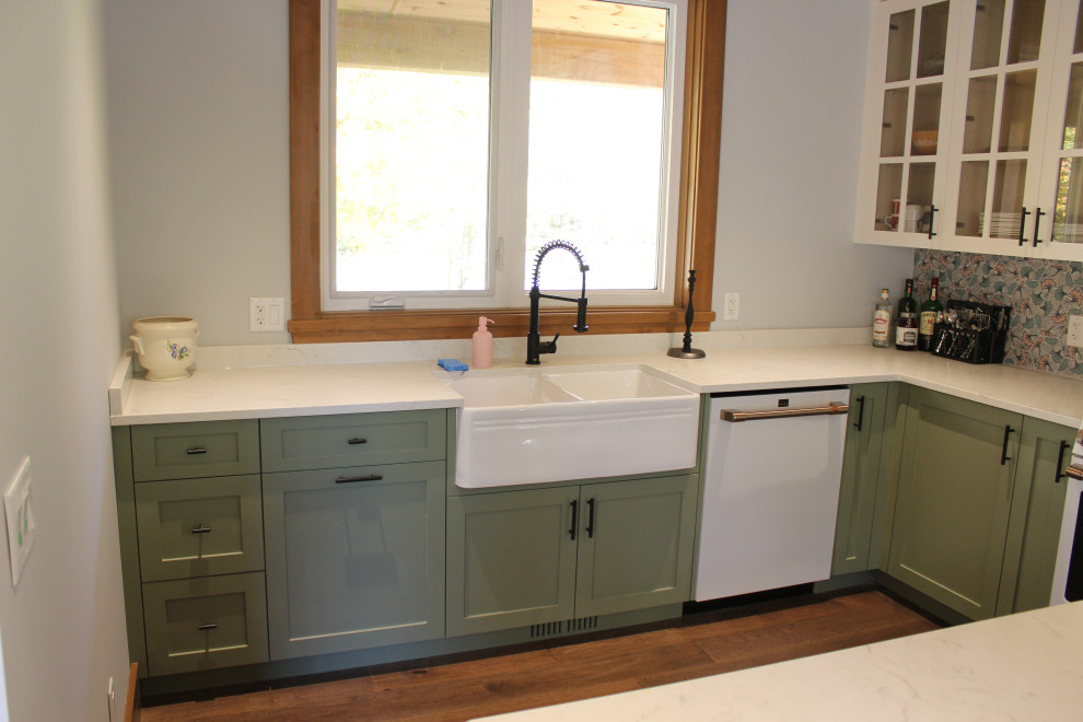 Eat-in kitchen - mid-sized rustic l-shaped dark wood floor and exposed beam eat-in kitchen idea in Toronto with a farmhouse sink, shaker cabinets, green cabinets, quartz countertops, green backsplash, mosaic tile backsplash, white appliances, an island and white countertops