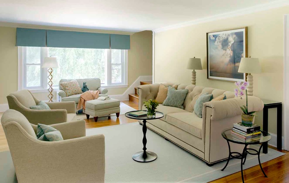 This is an example of a large transitional open concept living room in Boston with beige walls, medium hardwood floors, a standard fireplace and a wall-mounted tv.