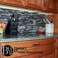Enclosed kitchen - mid-sized transitional u-shaped enclosed kitchen idea with an undermount sink, recessed-panel cabinets, medium tone wood cabinets, granite countertops, blue backsplash and glass tile backsplash