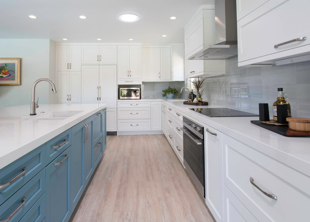 Large transitional l-shaped vinyl floor and beige floor open concept kitchen photo in San Diego with an undermount sink, shaker cabinets, white cabinets, quartz countertops, gray backsplash, ceramic backsplash, paneled appliances, an island and white countertops
