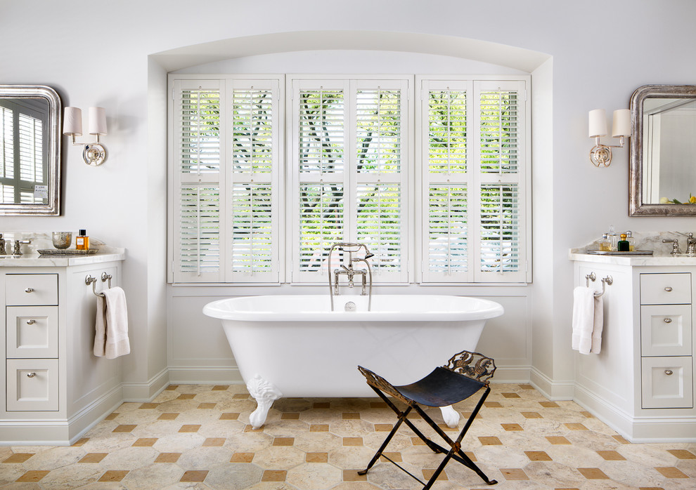 Huge elegant master claw-foot bathtub photo in Houston with recessed-panel cabinets and white cabinets