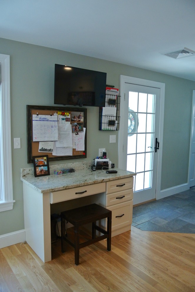 Eat-in kitchen - transitional galley light wood floor eat-in kitchen idea in Boston with an undermount sink, stainless steel appliances, an island, shaker cabinets, white cabinets, wood countertops, white backsplash, ceramic backsplash and brown countertops