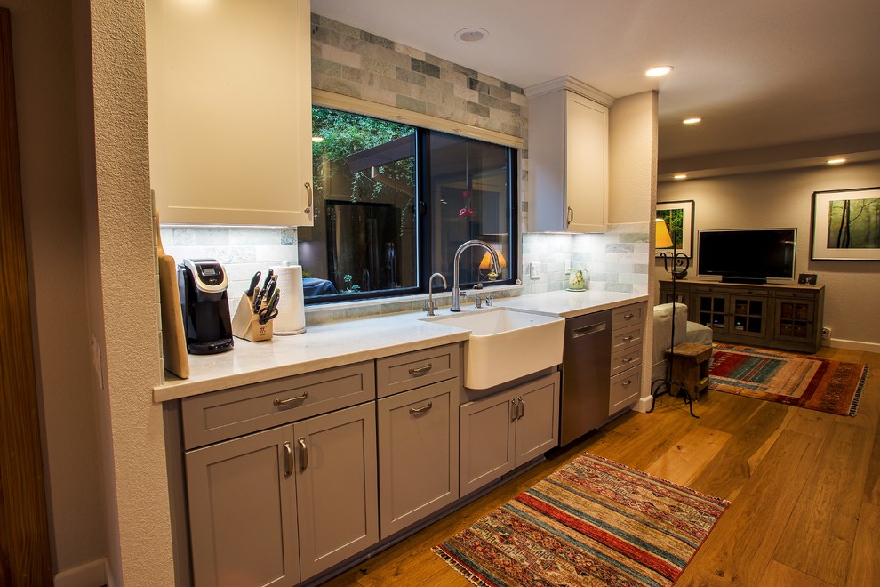 Inspiration for a large transitional galley light wood floor and brown floor open concept kitchen remodel in Sacramento with a farmhouse sink, shaker cabinets, gray cabinets, quartz countertops, gray backsplash, stone tile backsplash, stainless steel appliances, no island and white countertops