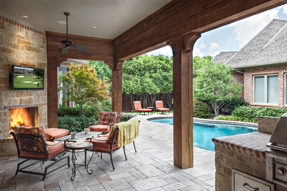 Photo of a large traditional backyard patio in Dallas with an outdoor kitchen, concrete pavers and a roof extension.