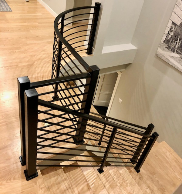 На фото: изогнутая лестница среднего размера в стиле модернизм с металлическими перилами