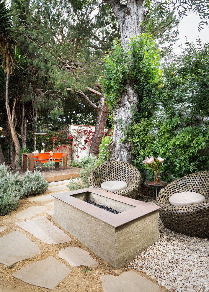 Photo of a mid-sized contemporary backyard patio in Los Angeles with a fire feature, natural stone pavers and no cover.