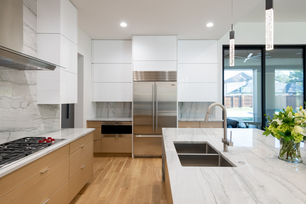 Inspiration for a mid-sized modern u-shaped light wood floor open concept kitchen remodel in Dallas with an undermount sink, flat-panel cabinets, white cabinets, quartzite countertops, white backsplash, paneled appliances, an island and white countertops