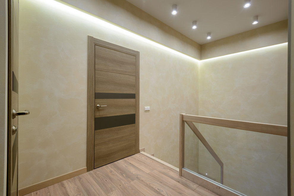 Inspiration for a large contemporary hallway in Novosibirsk with beige walls and light hardwood floors.