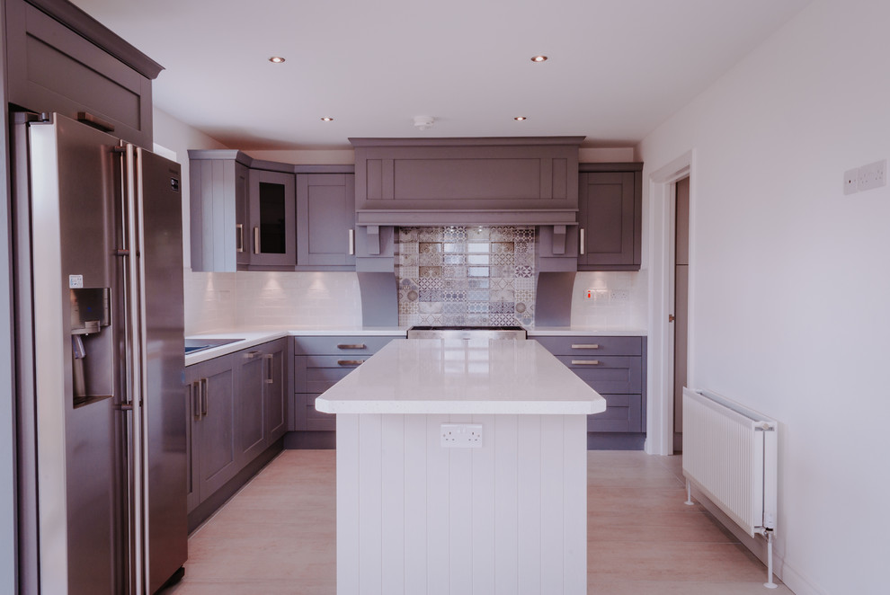 Mid-sized galley eat-in kitchen in Belfast with an integrated sink, shaker cabinets, blue cabinets, granite benchtops, ceramic splashback, stainless steel appliances, ceramic floors and with island.