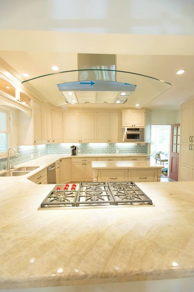 Mid-sized transitional u-shaped eat-in kitchen in Houston with an undermount sink, raised-panel cabinets, white cabinets, limestone benchtops, blue splashback, subway tile splashback, stainless steel appliances, porcelain floors, with island, brown floor and white benchtop.