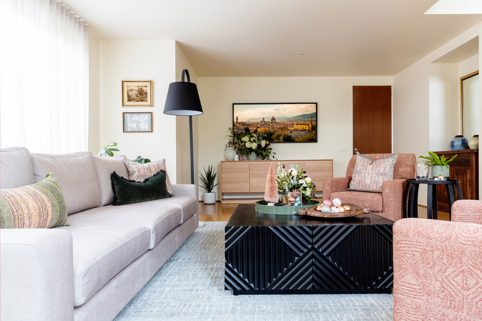 Aménagement d'un salon classique avec un mur beige, un sol en bois brun et un sol marron.