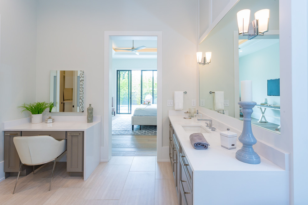 This is an example of a large transitional master bathroom in Orlando with recessed-panel cabinets, grey cabinets, a freestanding tub, an open shower, gray tile, pebble tile, beige walls, porcelain floors, an undermount sink, engineered quartz benchtops, beige floor, a hinged shower door, white benchtops, a double vanity and a built-in vanity.