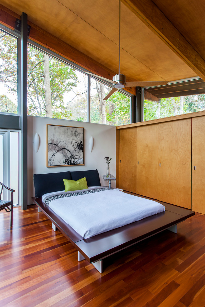 Example of a trendy medium tone wood floor bedroom design in Charlotte with white walls