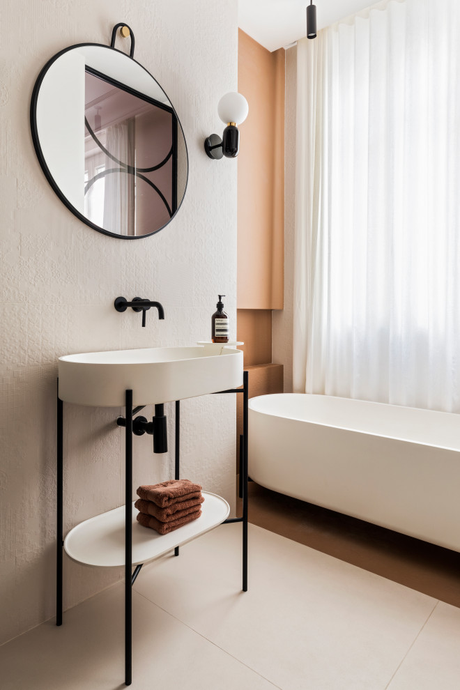 Modern inredning av ett mellanstort vit vitt en-suite badrum, med öppna hyllor, vita skåp, ett badkar med tassar, en dusch/badkar-kombination, beige kakel, keramikplattor, vita väggar, klinkergolv i keramik, ett piedestal handfat, bänkskiva i akrylsten, beiget golv och med dusch som är öppen