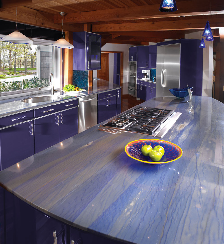 Photo of a large eclectic single-wall eat-in kitchen in Boston with an undermount sink, flat-panel cabinets, blue cabinets, marble benchtops, blue splashback, glass tile splashback, stainless steel appliances, medium hardwood floors and with island.