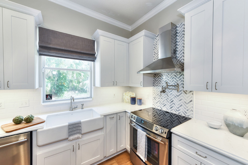 Large transitional l-shaped medium tone wood floor eat-in kitchen photo in Jacksonville with a farmhouse sink, shaker cabinets, quartz countertops and an island