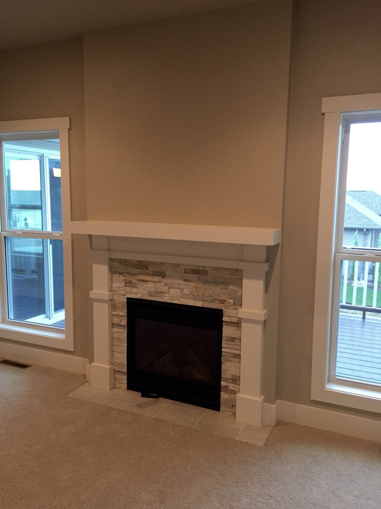 Photo of a mid-sized arts and crafts open concept living room in Other with beige walls, carpet, a standard fireplace and a stone fireplace surround.