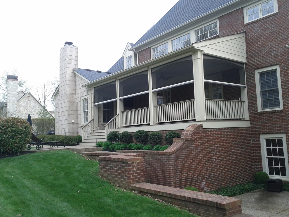 Mid-sized traditional backyard screened-in verandah in Louisville with decking and a roof extension.