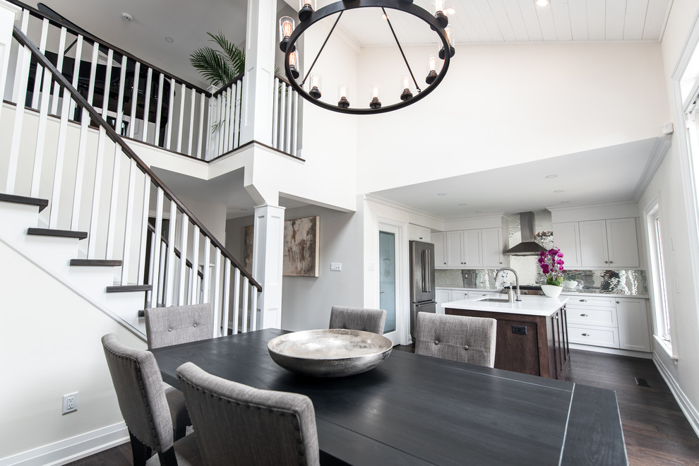 Inspiration for a mid-sized transitional l-shaped brown floor eat-in kitchen remodel in Toronto with a double-bowl sink, shaker cabinets, white cabinets, quartz countertops, metallic backsplash, stainless steel appliances, an island and white countertops