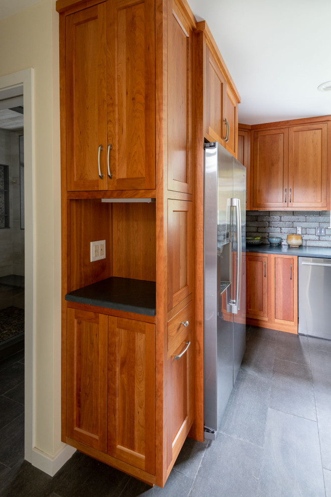 Eat-in kitchen - large transitional l-shaped porcelain tile and gray floor eat-in kitchen idea in Boston with a farmhouse sink, shaker cabinets, medium tone wood cabinets, quartz countertops, gray backsplash, porcelain backsplash, stainless steel appliances, an island and white countertops
