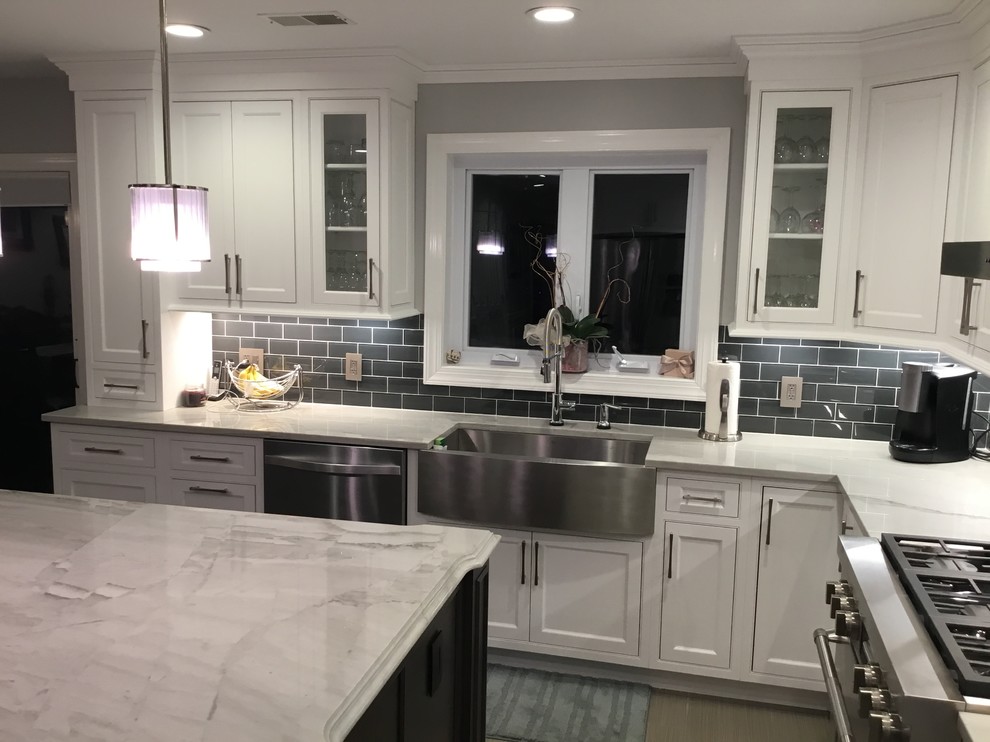 Kitchen - mid-sized transitional l-shaped porcelain tile and gray floor kitchen idea in New York with a farmhouse sink, beaded inset cabinets, white cabinets, quartzite countertops, gray backsplash, subway tile backsplash, stainless steel appliances, an island and white countertops