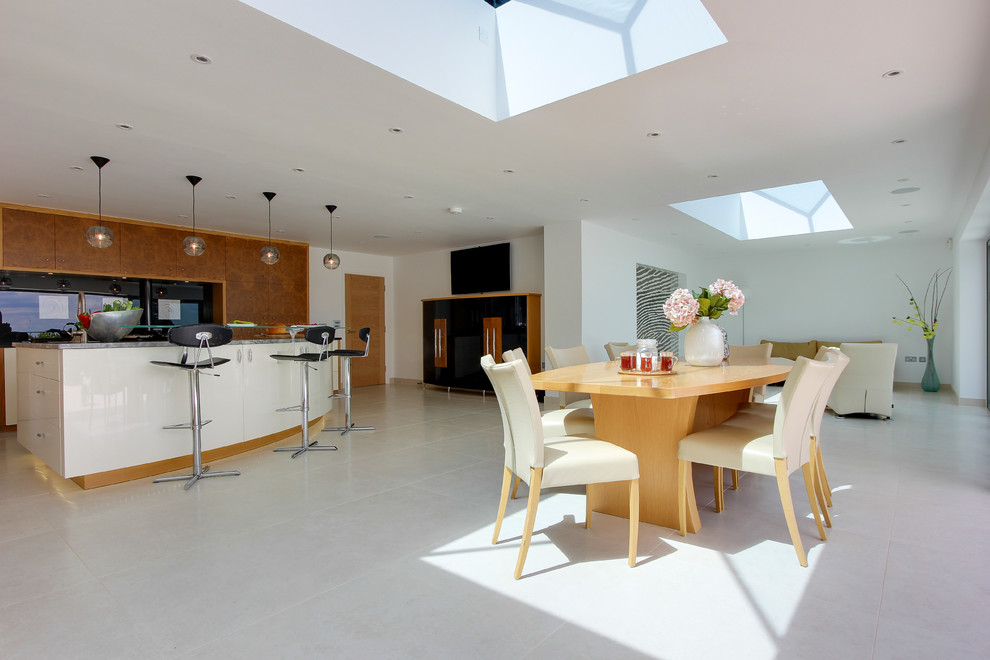 This is an example of a large contemporary kitchen in London with panelled appliances, porcelain floors and with island.
