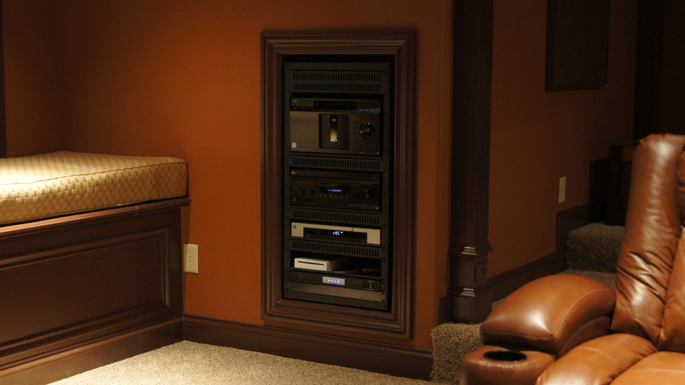 Photo of a mid-sized traditional enclosed home theatre in Other with brown walls and carpet.